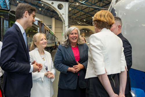 Transport Secretary Heidi Alexander speaking to others with museum trains in background
